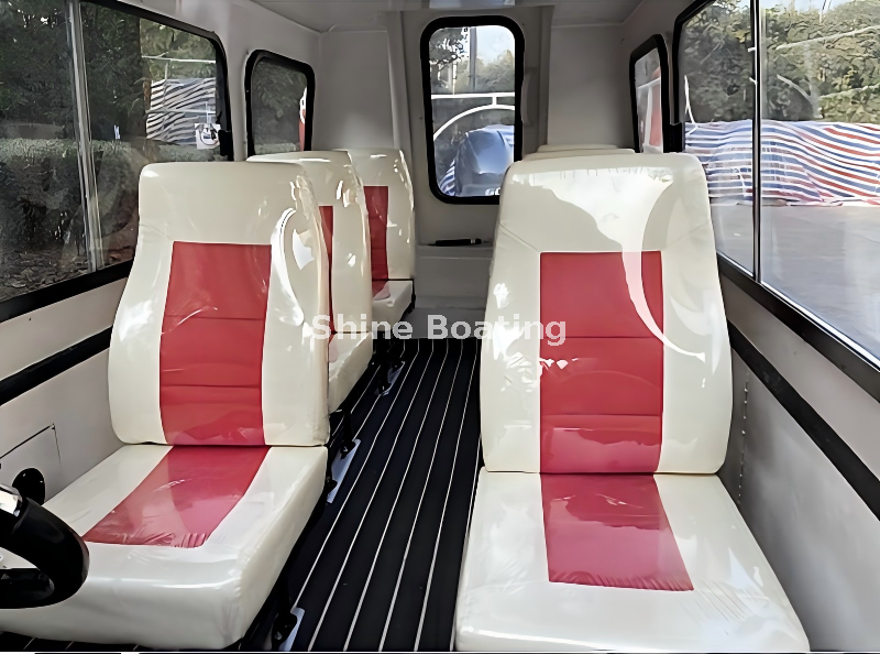 SHINE 600 Cabin Boat Interior – Passenger Seats Interior of SHINE 600 cabin boat with red and white cushioned passenger seats, large side windows and non-slip flooring